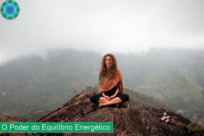 Mulher em posição de meditação em cima de uma pedra numa montanha