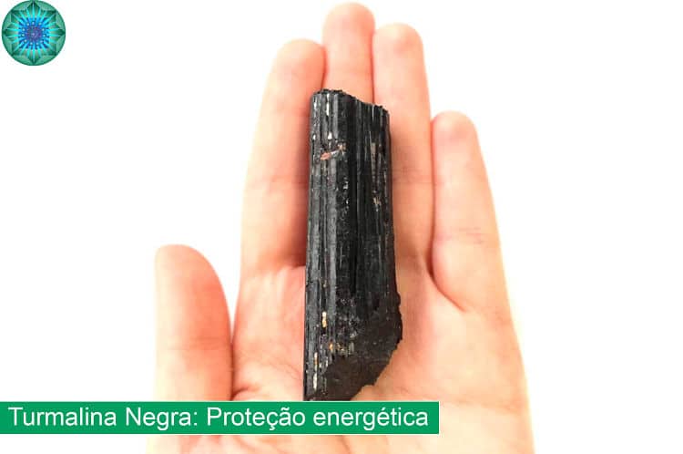 mão segurando cristal turmalina negra 